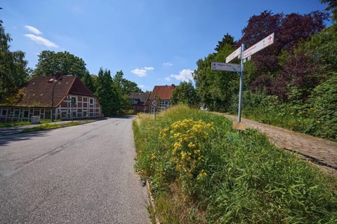Thoroughfare with old half-timbered houses and signposts in the Moorburg district, Free and