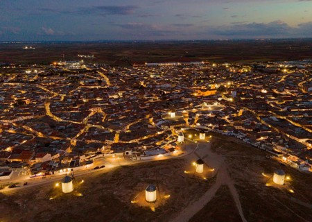 Night view of a village with illuminated windmills. The streets of the village are illuminated by