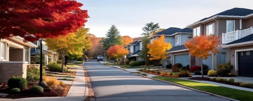 A serene suburban street featuring modern homes in autumn with colorful plants, AI generated