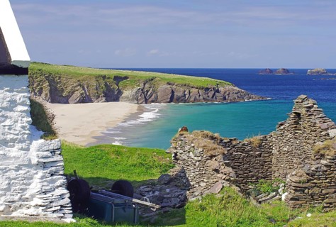Stone ruins and farmhouse on a rocky coast with sandy beach, Blasket Islands, Dunmore Head,