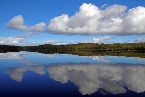 Reflection of clouds in a calm lake under a blue sky, Letterfrack, Connemara National Park,