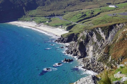 View of rocky coastline with beach and houses in the background, Kell Beach, Achill Island, County