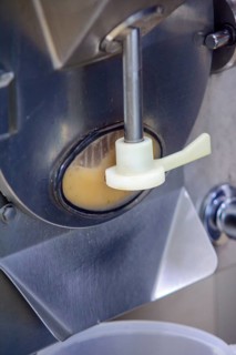 Close-up of a machine dispensing ice cream mix during production