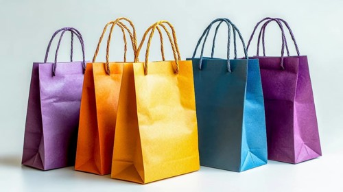 Five bright paper bags in various colors including orange, blue, and purple on a white background,