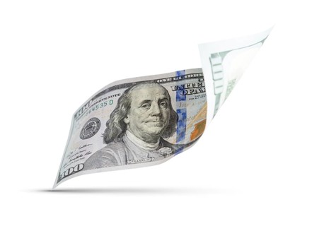 One hundred dollar bill floating down to surface with drop shadow isolated on a white background