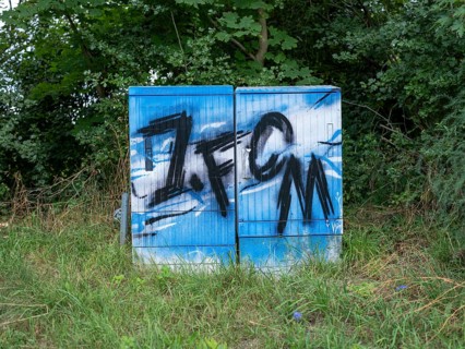 Blue and white graffiti 1. FCM (football club 1.FC Magdeburg) on an electricity box at Jersleber