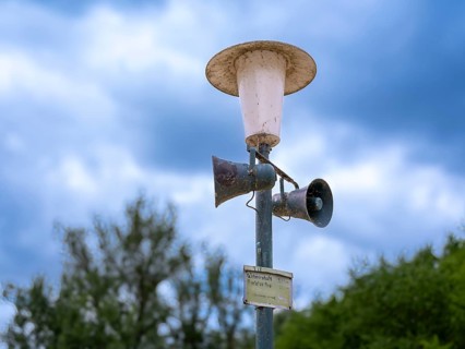 Weathered street lamp with loudspeakers next to a campsite on Lake Jersleben, Jersleben,