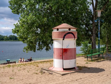 Old round red-white-ringed changing room from GDR times in the shape of a lighthouse on the shore