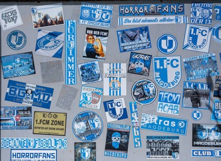 Stickers of Ultras, horror fans, hardcore fans of the football club 1. FC Magdeburg on a board at