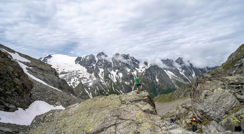 Mountaineer in a rocky saddle, Lapenscharte with view of mountain peaks and glacier into the valley