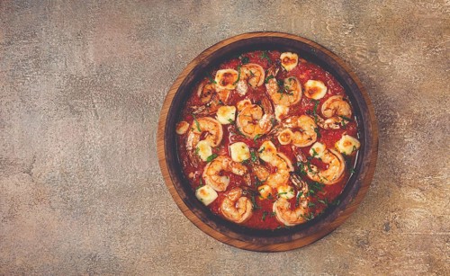 Saganaki with shrimp, in a clay pan, Greek dish, shrimp in tomato sauce, feta cheese, homemade, no