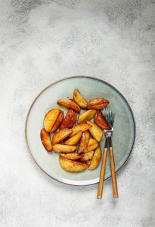 Fried potato slices, on a plate, top view, homemade, no people