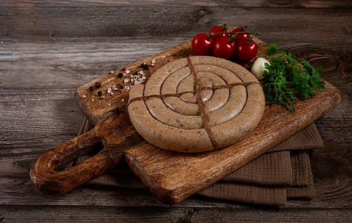 Raw spiral sausages, on a wooden board, top view, no people