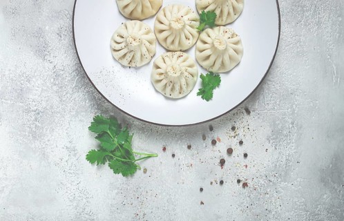 Khinkali, a traditional Georgian dish, with spices and herbs, top view, no people, on a white plate