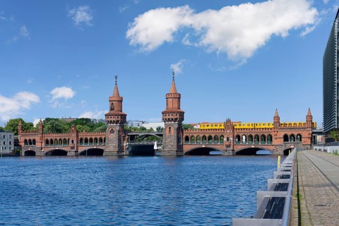 Yellow S-Bahn crossing the Double deck Oberbaum bridge over the Spree river, Berlin, Germany,