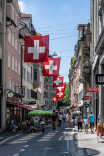 The Multergasse, pedestrian zone, shopping alleyway, decorated with Swiss national flags in the