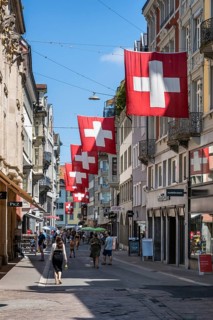 The Multergasse, pedestrian zone, shopping alleyway, decorated with Swiss national flags in the