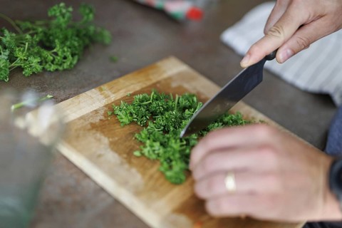 Cooking topic. A man chops fresh parsley. Berlin, 01.08.2024