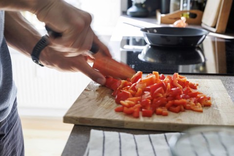 Cooking topic. A man cuts a sweet pepper. Berlin, 01.08.2024