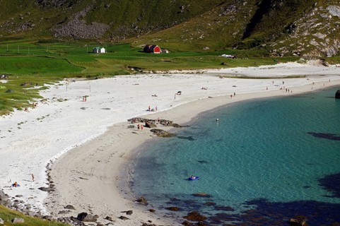 A white sandy beach with people, turquoise water and cliffs in the background, Haukland, Leknes,