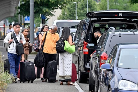 Tourists with wheeled suitcases