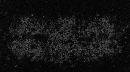Abstract black and white image with a speckled, grainy texture, creating a dark and mysterious