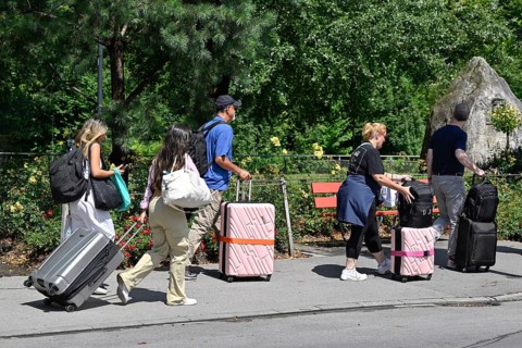 Tourists with wheeled suitcases