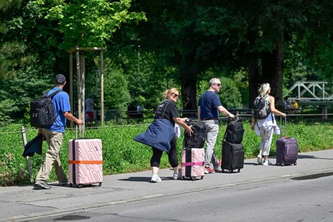 Tourists with wheeled suitcases