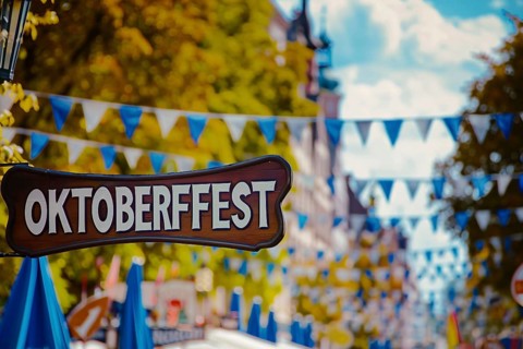 Wooden sign with text 'Oktoberfest' at entry of traditional Bavarian German festival. Generative
