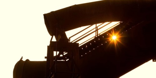 The sun shines through large former industrial pipes in the Westpark with a pigeon, industrial