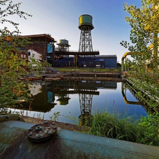 The water tower is reflected in the water basins at the Jahrhunderthalle in Westpark, Industrial