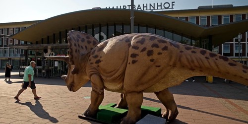 Triceratops model, three-horned dinosaur on the square in front of the main railway station, Dino