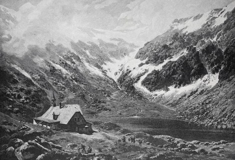A small hut in a snowy valley, surrounded by high mountains, small pond in the Giant Mountains,