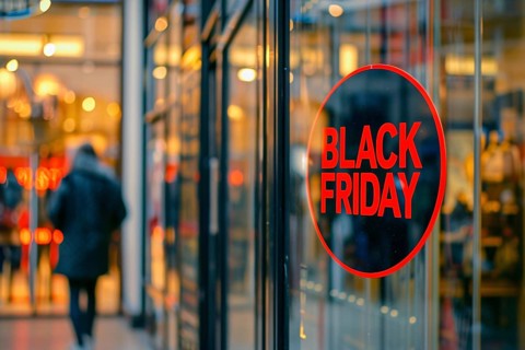 Round black advertisement sign with red text 'Black Friday' in shopping window. Generative AI, AI