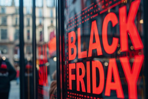 Black advertisement sign with red text 'Black Friday' in shopping window. Generative AI, AI