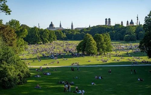 View from the Monopteros in the English Garden, meadows full of visitors on a summer day, Munich
