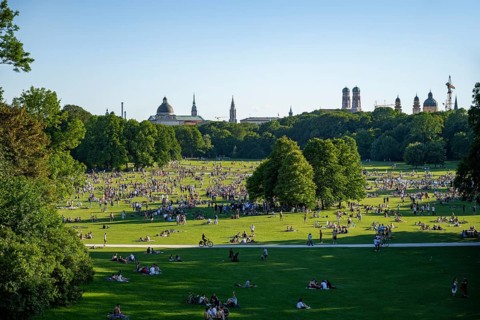 View from the Monopteros in the English Garden, meadows full of visitors on a summer day, Munich