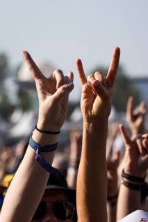 Metal fans show the French fries fork, a greeting in the metal scene, at the Wacken Open Air in