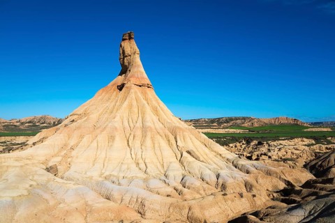 Striking rock formations rise up in an arid landscape under a deep blue sky, Castildetierra,