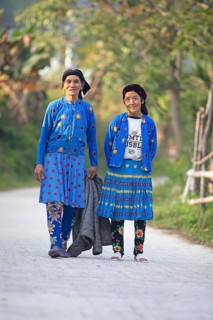 Two Hmong minority woman in everyday clothes stand on a street and look into the camera, Du Gia, Ha