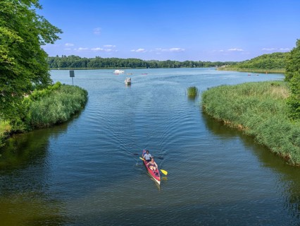 Paddle boat, paddler, and small motorboat on the Havel between Baalensee and Schwedtsee (behind),