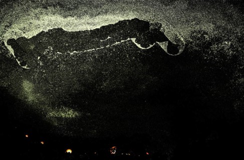 Dark abstract scene with speckles and faint yellow lights, creating a mysterious and eerie