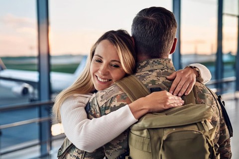 A woman hugs a soldier in an airport area at sunset, AI generated, AI generated