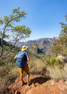 Hiker looking at canyon landscape, River loop at Blyde River Canyon with Three Rondawels peak, View