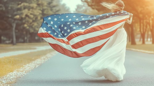 Woman with flowing dress and American flag runs along a road in a windy and sunlit scene, AI