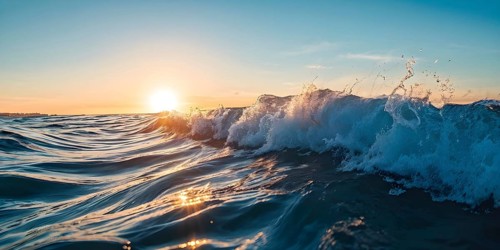 Ocean wave cresting with foam water glistening under sunlight, AI generated