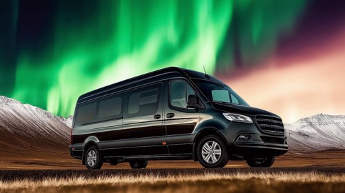 A van parked in a wilderness setting with the northern lights illuminating the sky above a mountain