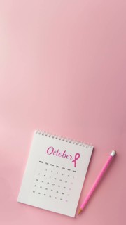 October calendar with a breast cancer awareness pink ribbon and a pencil with copyspace. Vertical