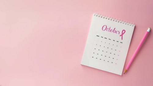 October calendar with a breast cancer awareness pink ribbon and a pencil with copyspace, AI