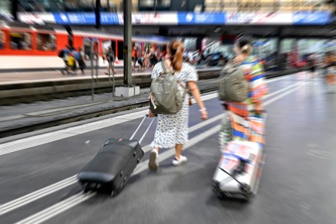 Wipe-off picture SBB railway station passers-by with trolley case